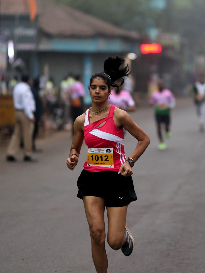 Rinky Singh, first-rank female winner of the 10K run at Chiplun Half Marathon 2025, proudly celebrates her success.