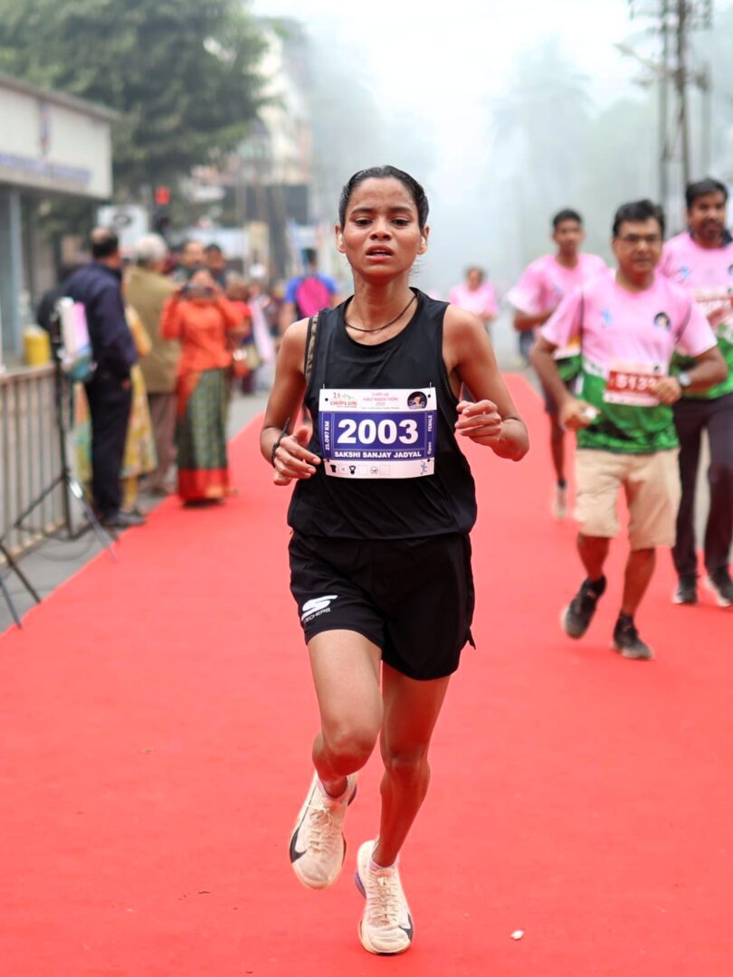 Sakshi Sanjay Jadyal, first-rank female winner of the 21K Chiplun Half Marathon 2025, proudly celebrates her victory.