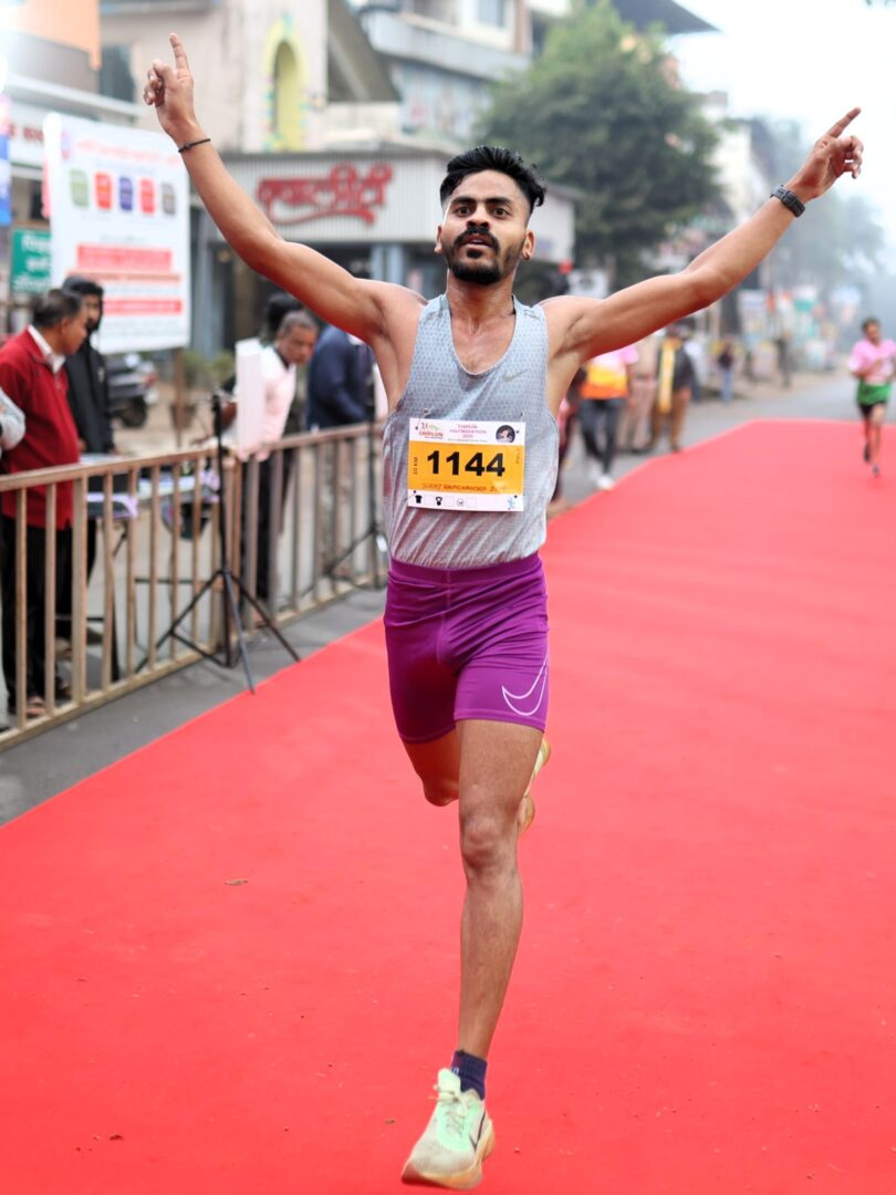 Suraj Ramchandra Zore, winner of the 10K run at Chiplun Half Marathon 2025, proudly celebrates his achievement.